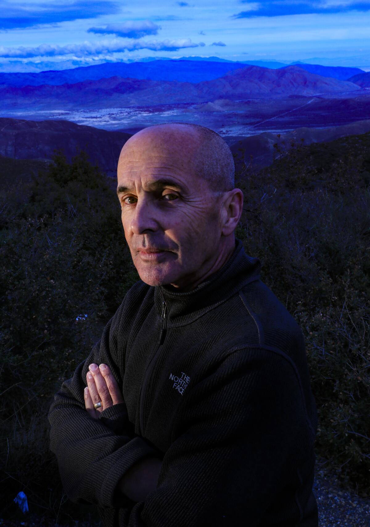 Novelist Don Winslow stands on a hilltop in San Diego County overlooking a portion of the Borrego Valley where people and drugs coming from Mexico sometimes intersect on the desert floor below him.