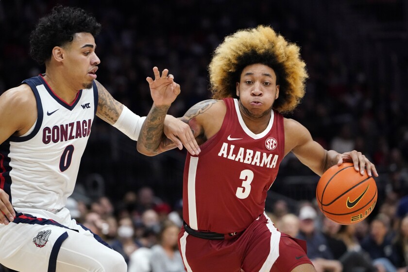 Alabama's JD Davison (3) tries to drive past Gonzaga's Julian Strawther (0) during the first half of an NCAA college basketball game Saturday, Dec. 4, 2021, in Seattle. (AP Photo/Elaine Thompson)