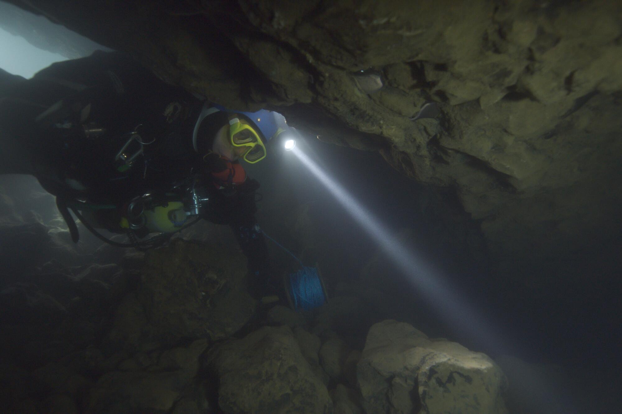 A man dives in a cave