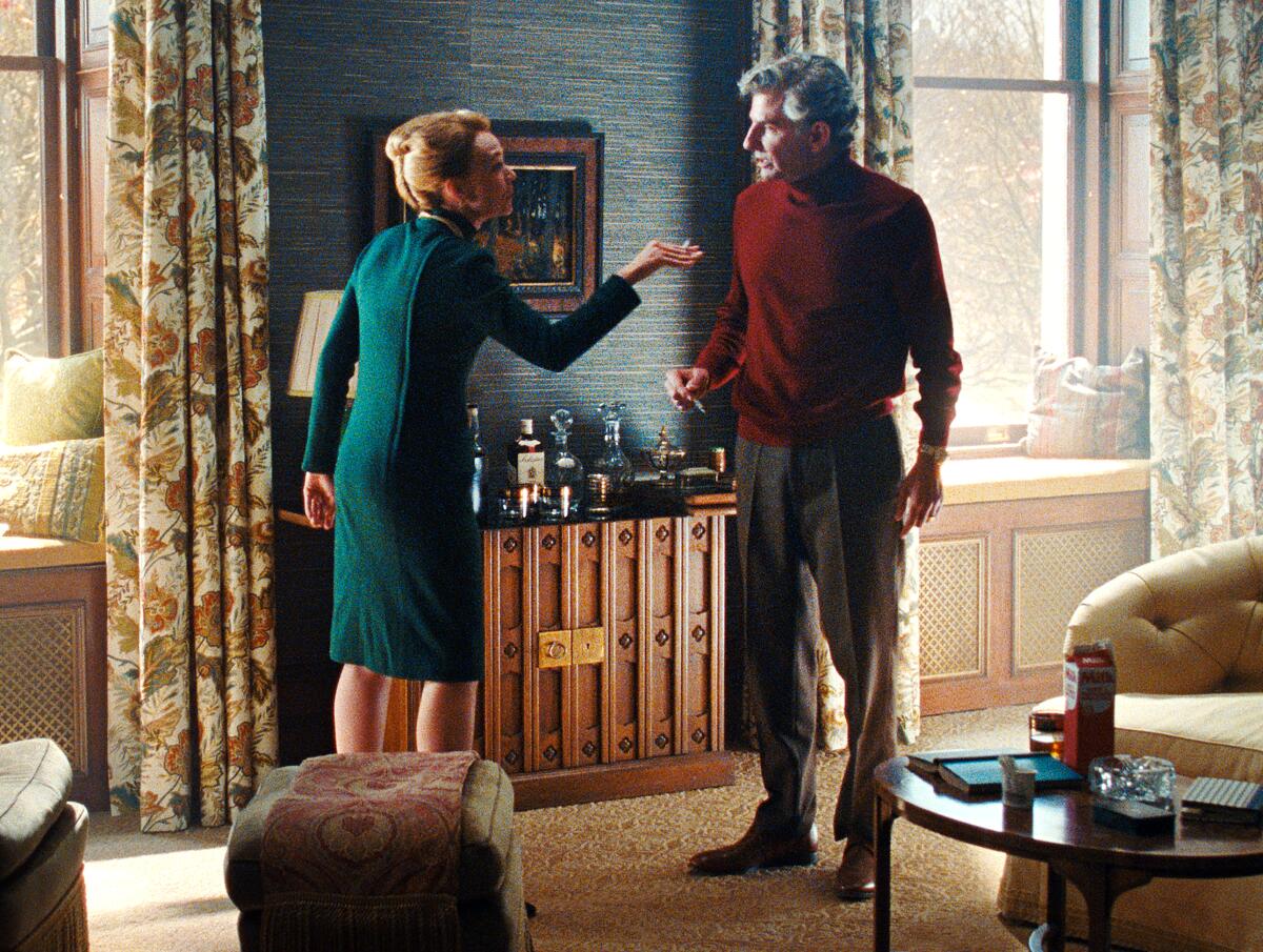 A man and woman argue standing in a living room in "Maestro."