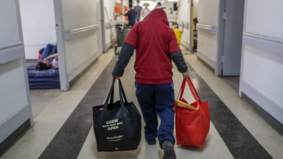 MCALLEN, TEXAS, SATURDAY, JANUARY 19, 2019 - A young immigrant boy carries his belongings through the halls of the Catholic Charities Respite Center temporary facility on his way to another city. (Robert Gauthier/Los Angeles Times)