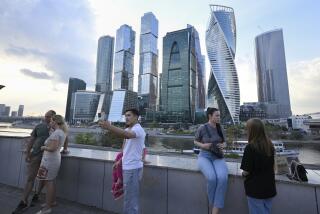 People stroll at embankment of the Moscow River in Moscow, Russia, Tuesday, Aug. 1, 2023, with the "Moscow City" business district in the background. The glittering towers of the Moscow City business district were once symbols of the Russian capital's economic boom in the early 2000s. Now they are a sign of its vulnerability, following a series of drone attacks that rattled some Muscovites shaken and brought the war in Ukraine home to the seat of Russian power. (AP Photo/Dmitry Serebryakov)