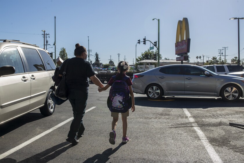 Imelda Arroyo camina con su hija Marisol, de 7años, después determinar su trabajo en Oakland el 30 de septiembre de 2021. Arroyo es miembro de'Fight for $ 15', unaorganización paratrabajadores de bajos salarios.Reichaves / Bay Area Newsgroup