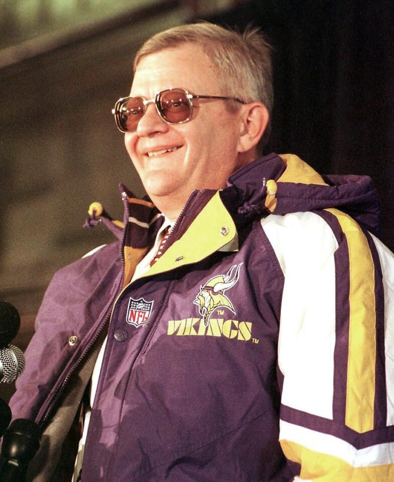 Tom Clancy smiles as he wears a Minnesota Vikings jacket during a press conference, announcing the sale of the team to Clancy.