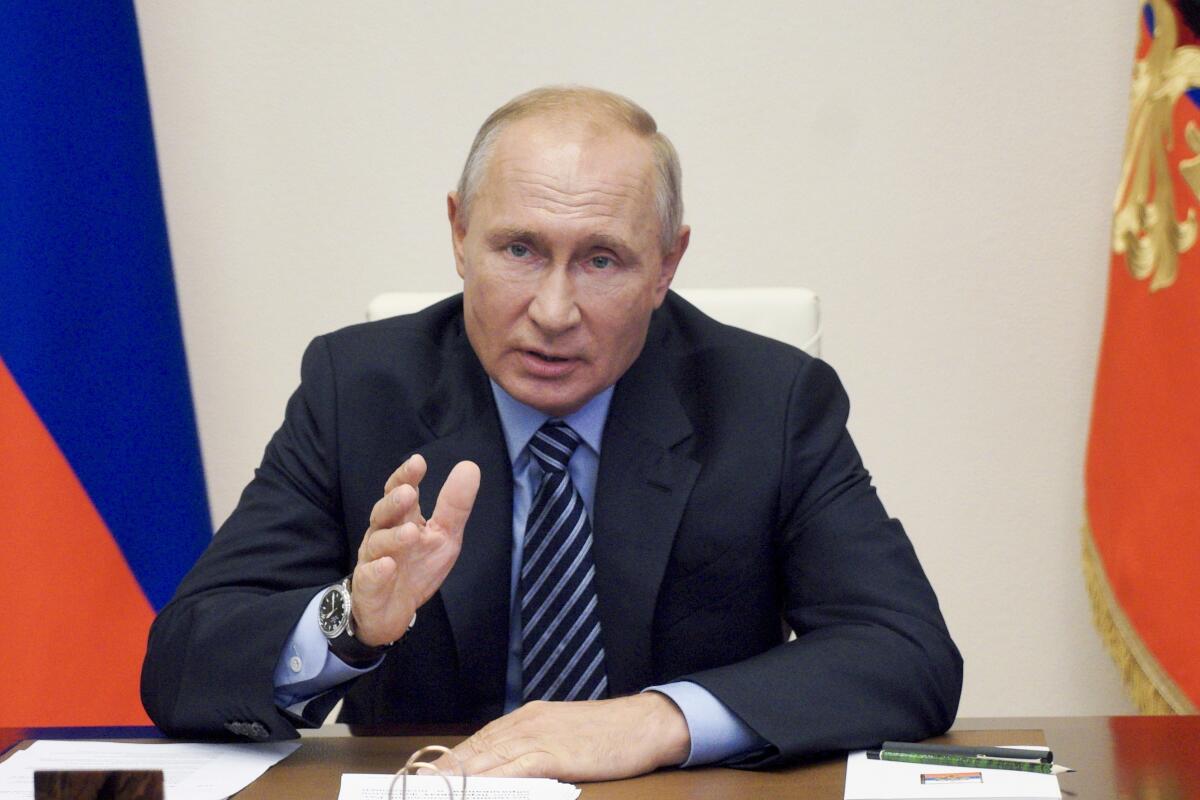 Russian President Vladimir Putin gestures during a videoconference meeting at the Novo-Ogaryovo residence outside Moscow.