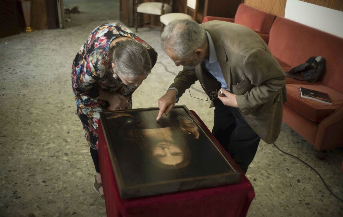 Dianne Modestini, left, and Ashok Roy inspect the Naples copy of the Salvator Mundi in a scene from 'The Lost Leonardo'