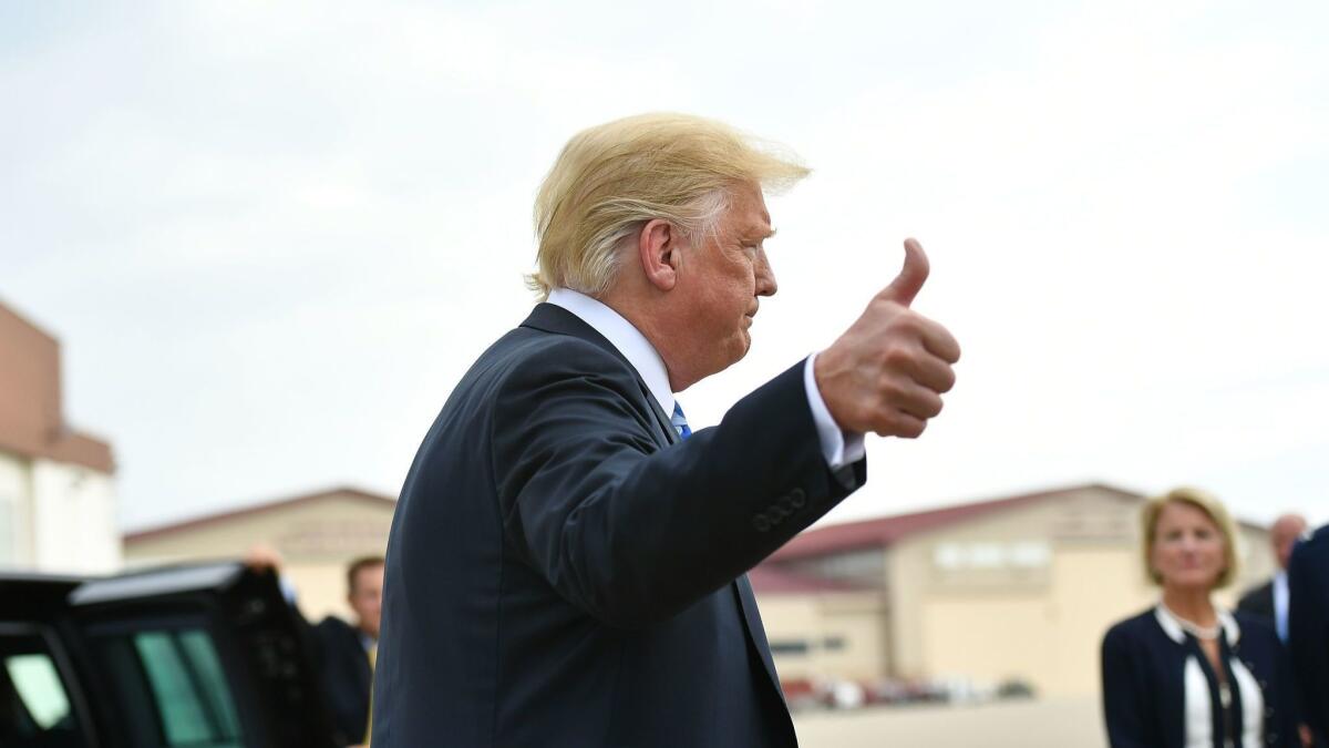 President Trump gives reporters a thumbs-up after arriving in West Virginia for a political rally on Tuesday, shortly after a federal jury convicted his former campaign chairman in Virginia and his former personal lawyer pleaded guilty in New York.
