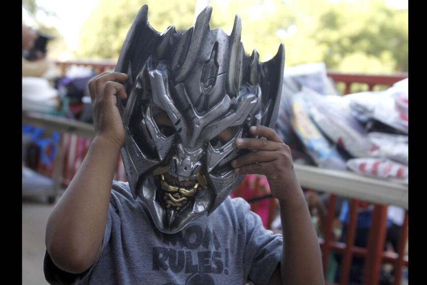 Three-year-old Alexis Hernandez tries on his new Transformer mask at the Mar Vista Family Center in Culver City.
