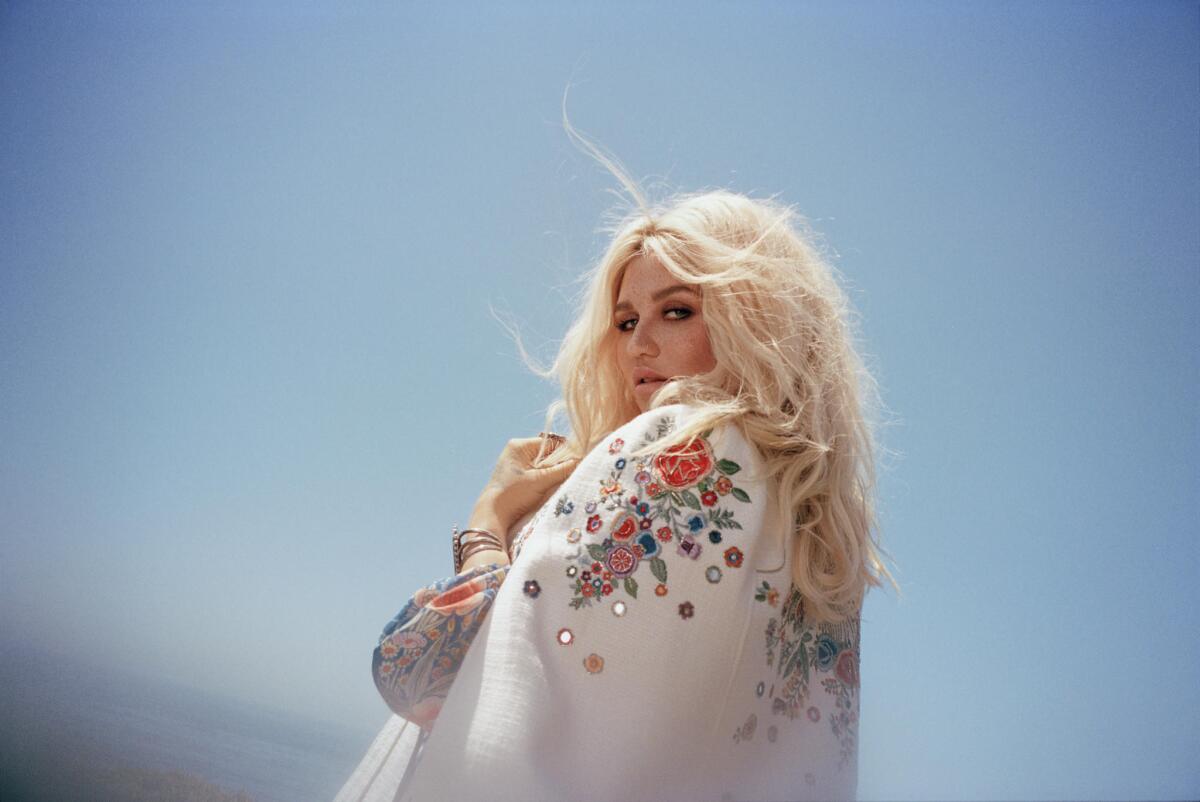 Kesha wears a white coat embroidered with flowers
