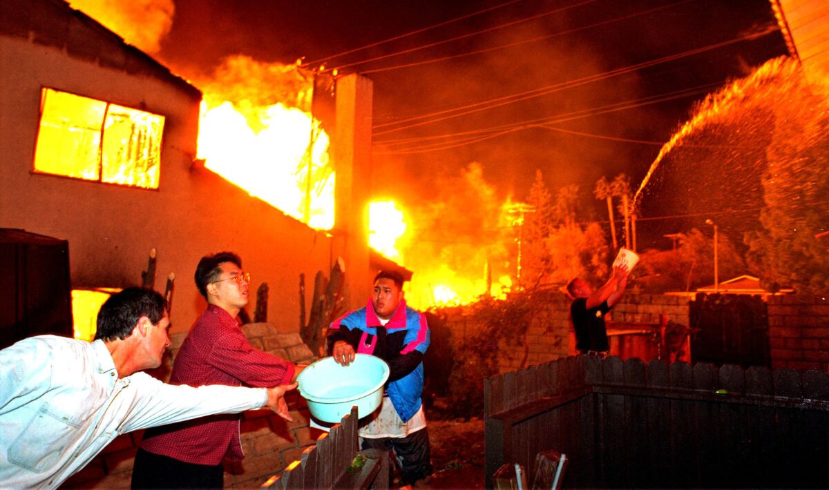 Neighbors use a bucket brigade to fight a fire in the 11700 block of Balboa Boulevard in Granada Hills.