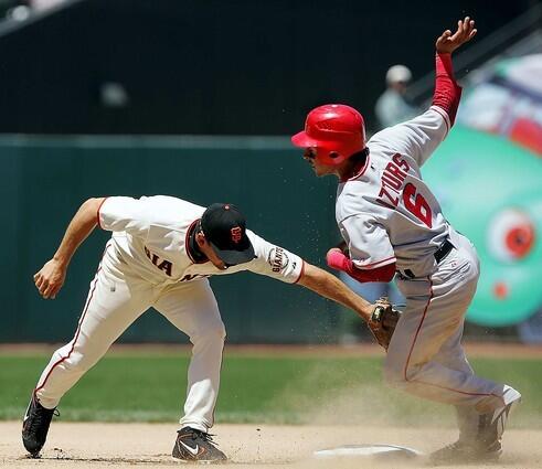 Los Angeles Angels Maicer Izturis, right, is safe at second as San Francisco Giants shortstop Omar Vizquel, left, attempts a tag on a pick-off attempt.