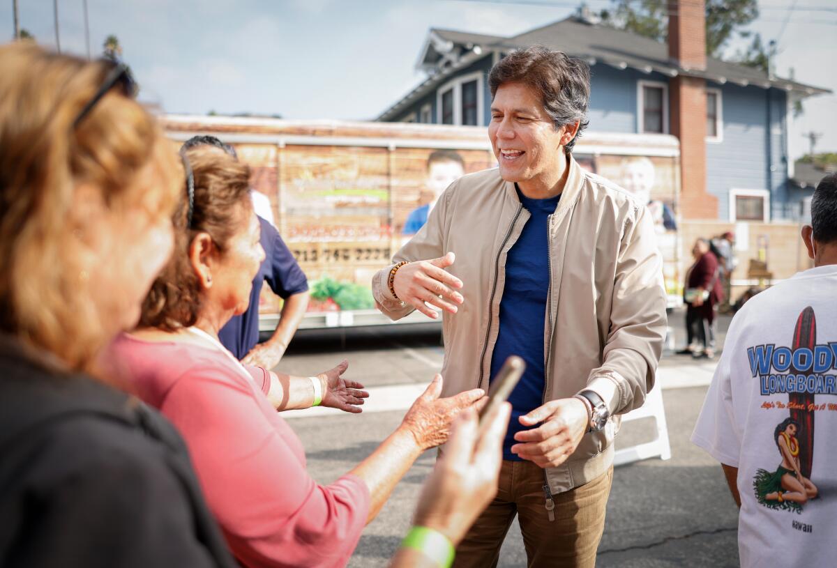 Councilmember Kevin De León greets people in line for a food distribution outside his office in Eagle Rock.