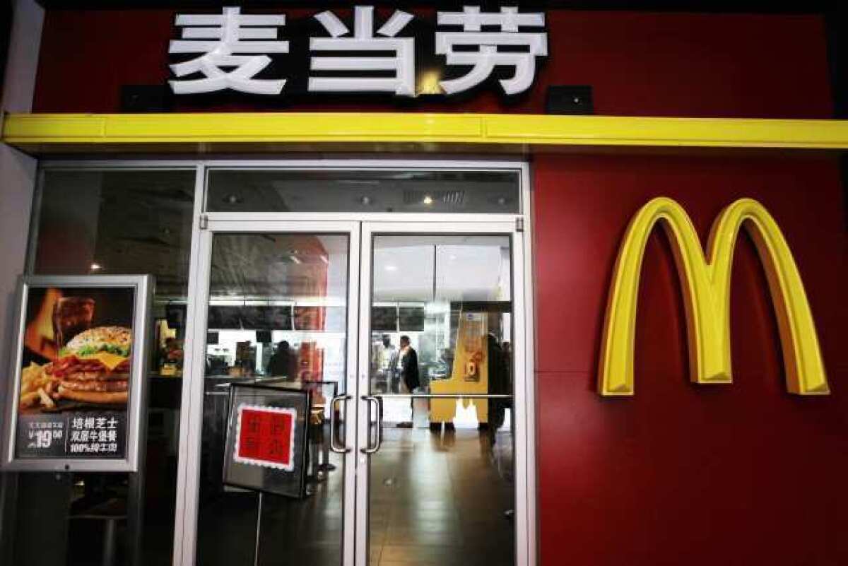 A sign is posted in front of a McDonald's outlet in Sanlitun saying it is closed after Chinese state television accused it of selling expired chicken products.