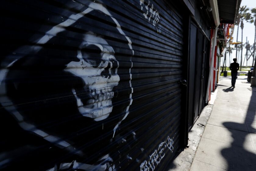 LOS ANGELES, CALIF. -MAR. 18, 2020. Shuttered shops line Windward Avenue in Venice Beach on Wednesday, Mar. 18, 2020., Many restaurants and shops on the strand have closed as a safety measure against the spread of coronavirus. (Luis Sinco/Los Angeles Times)