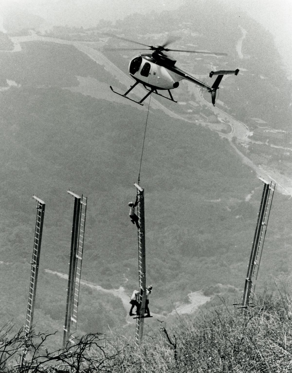 A helicopter delivers a support for the 1978 rebuild of the Hollywood sign.