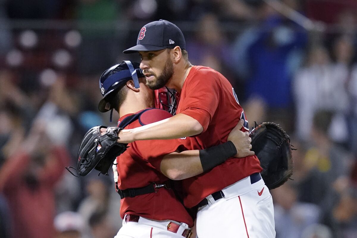 Boston Red Sox closer Matt Barnes, right, hugs catcher Christian Vazquez after the Red Sox's 12-8 victory over the Houston Astros in a baseball game at Fenway Park, Thursday, June 10, 2021, in Boston. (AP Photo/Elise Amendola)