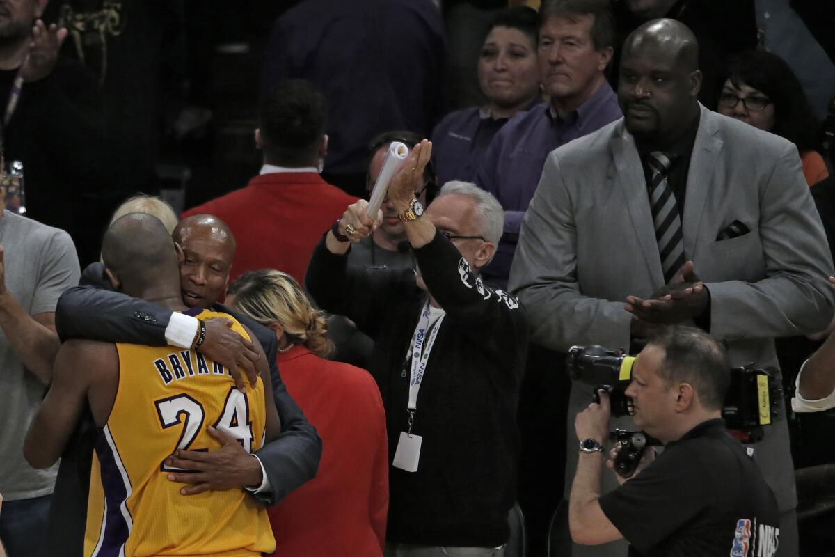 Kobe Bryant hugs Lakers coach Byron Scott as he exits his last game.