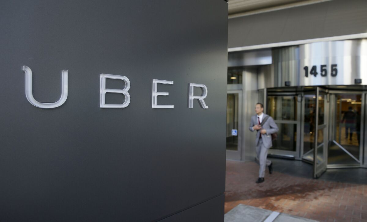 A man leaves Uber's headquarters in San Francisco. Ride-sharing services like Uber are now more popular among business travelers than taxis.