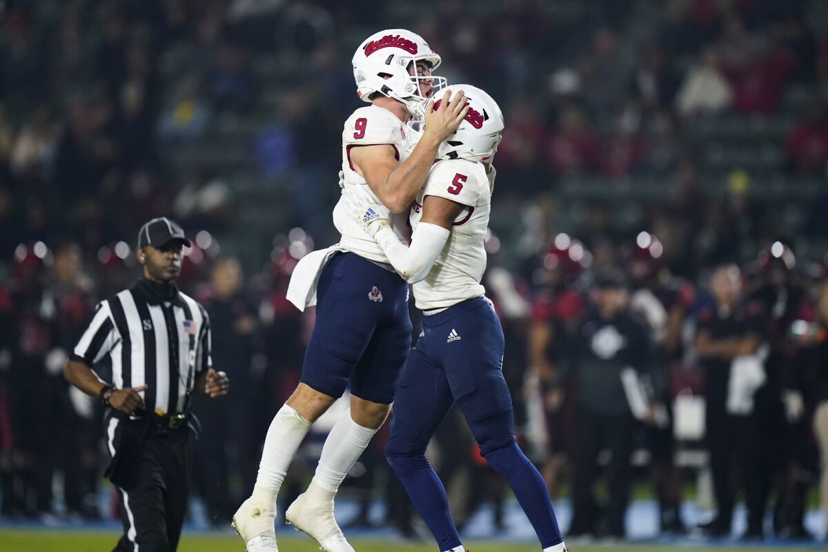 Fresno State quarterback Jake Haener, left, and wide receiver Jalen Cropper celebrate a touchdown by Keric Wheatfall during the first half of the team's NCAA college football game against San Diego State on Saturday, Oct. 30, 2021, in Carson, Calif. (AP Photo/Jae C. Hong)