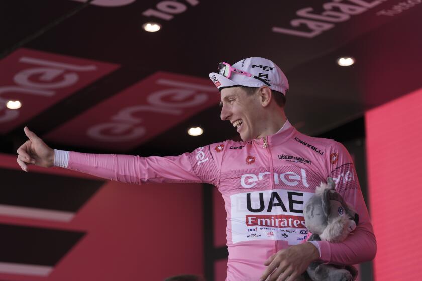 Tadej Pogacar celebrates retaining the pink jersey of leader of the race after stage 14 of the Giro d'Italia 2024, in Desenzano del Garda, Italy, Saturday, May 18, 2024. (Massimo Paolone/LaPresse via AP)