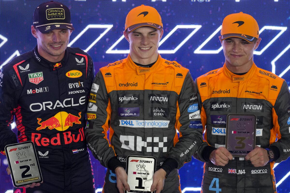 Red Bull driver Max Verstappen stands next to McLaren's driver Oscar Piastri, center, and Lando Norris.