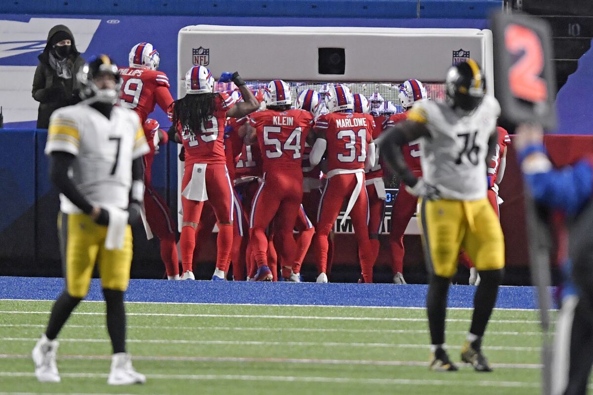 Pittsburgh Steelers quarterback Ben Roethlisberger (7) and Chukwuma Okorafor (76) walk off the field as the Buffalo Bills defense celebrates a 51-yard interception returned for a touchdown during the first half of an NFL football game in Orchard Park, N.Y., Sunday, Dec. 13, 2020. (AP Photo/Adrian Kraus)