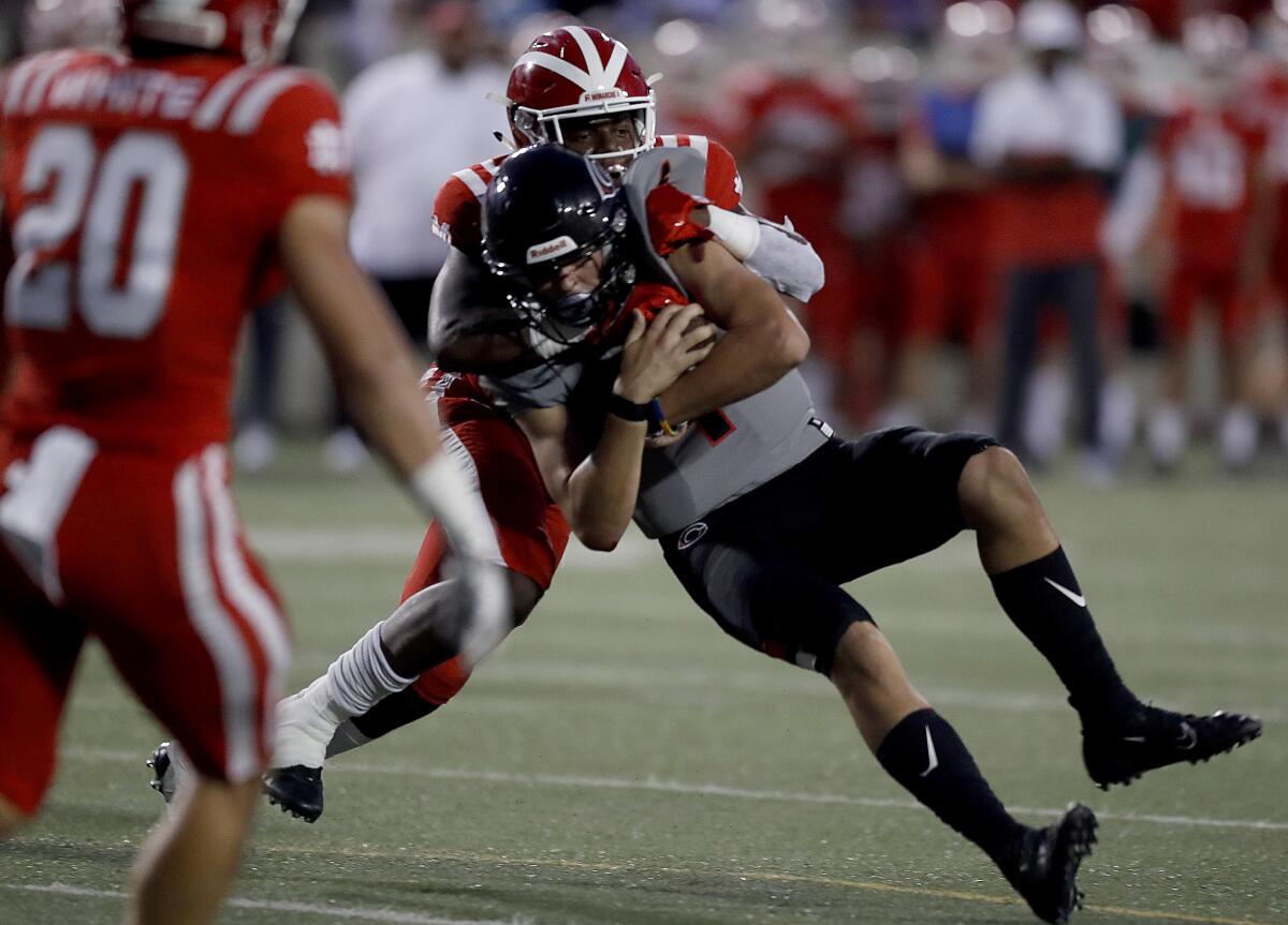Mater Dei linebacker Raesjon Davis brings Corona Centennial quarterback Carter Freedland down for a loss