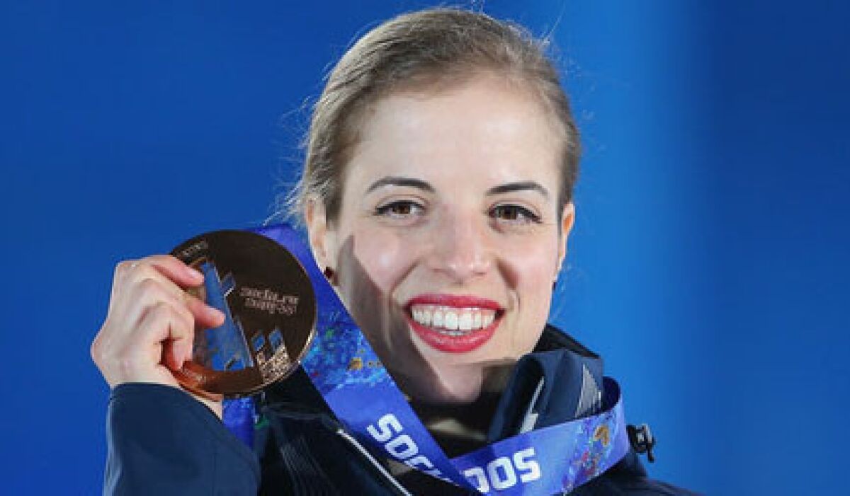 Italian figure skater Carolina Kostner holds up her bronze medal during the Sochi 2014 Winter Olympics.