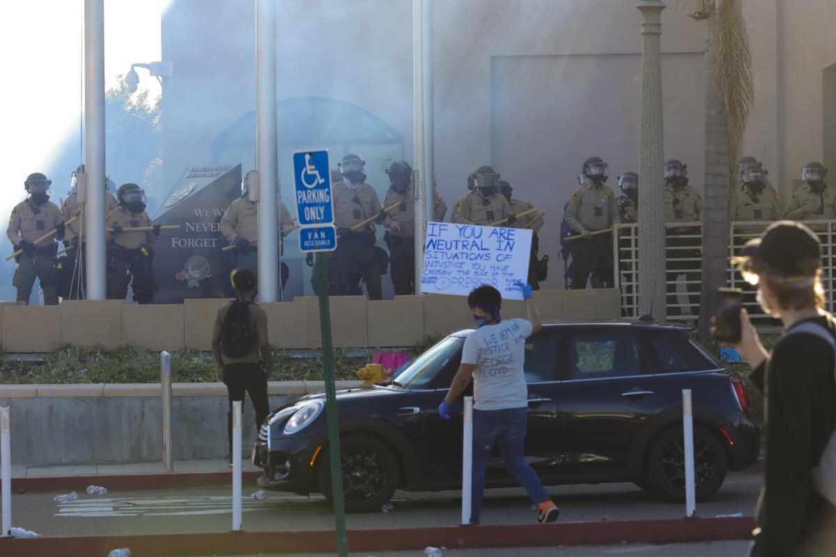 Sheriff's deputies take up positions at an entrance to the La Mesa Police Department 