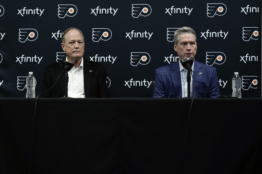 Philadelphia Flyers chairman Dave Scott, left, and Flyers general manager Chuck Fletcher take part in a news conference at the team's NHL hockey practice facility, Wednesday, Jan. 26, 2022, in Voorhees, N.J. The Flyers have lost a team-record 13 straight games. (AP Photo/Matt Rourke)