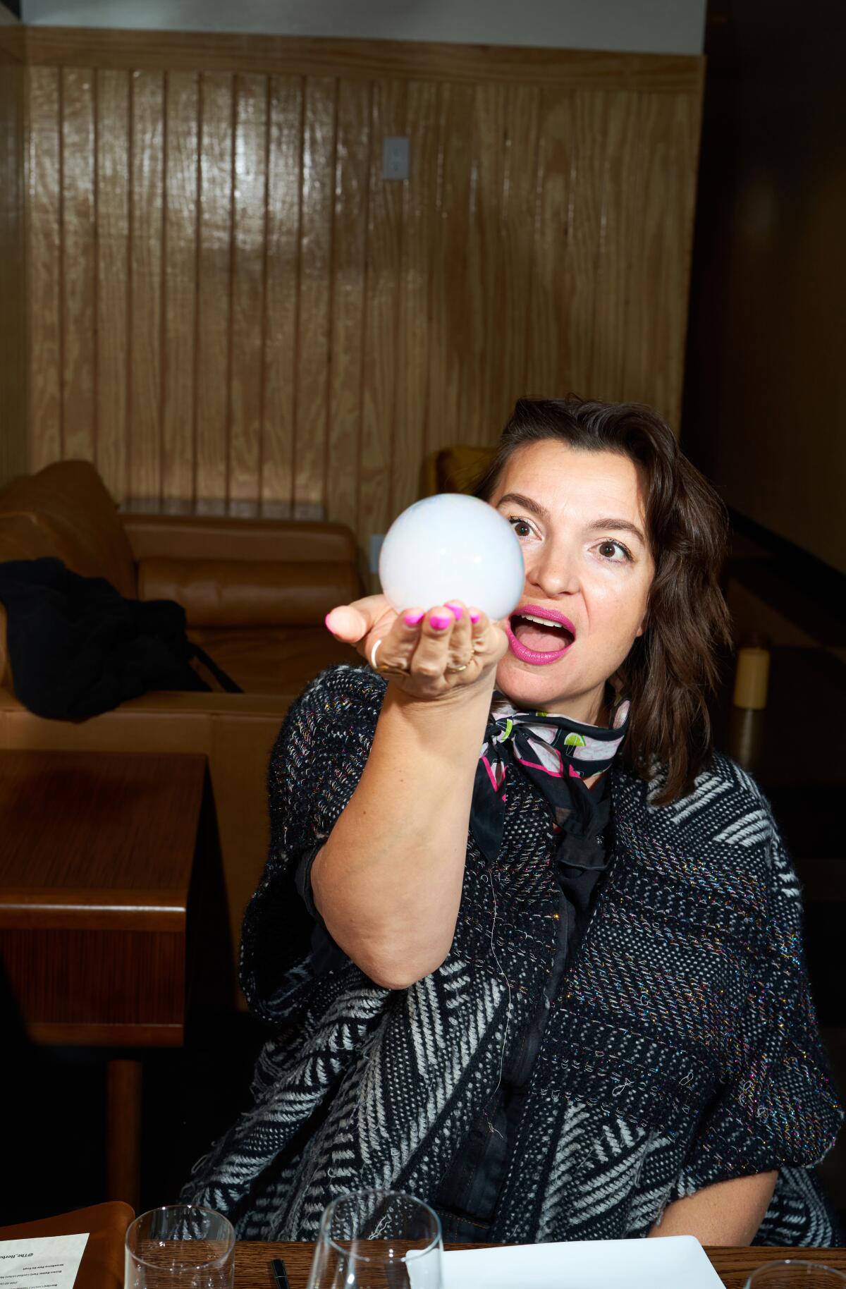 A diner holds a smoke-filled bubble in her hand.