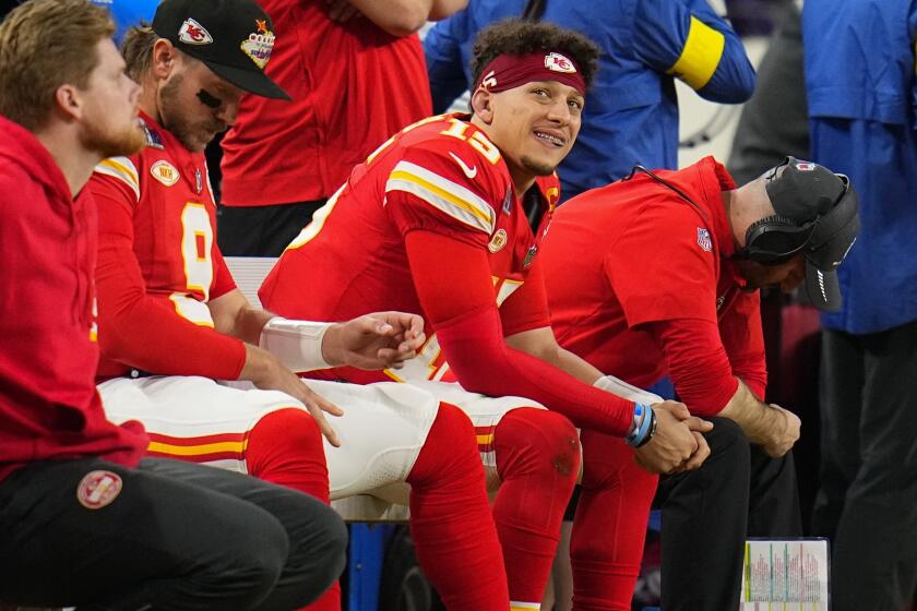 Kansas City Chiefs quarterback Patrick Mahomes smiles while sitting on the bench during the second half of the Super Bowl.