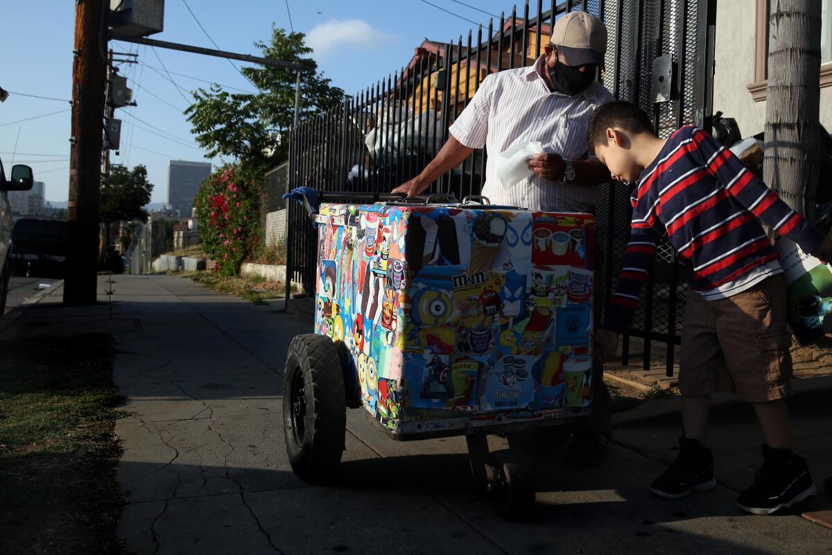 Matthew Chicas, 6, buys a paleta from Mauro Rios Parra. The boy has been buying ice cream from Parra his entire life.