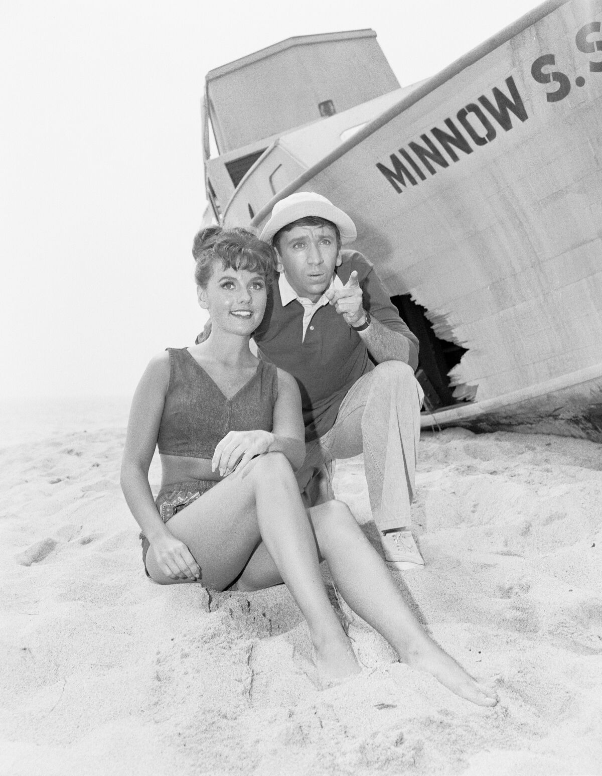 Dawn Wells and Bob Denver in the sand next to the S.S. Minnow on "Gilligan's Island."
