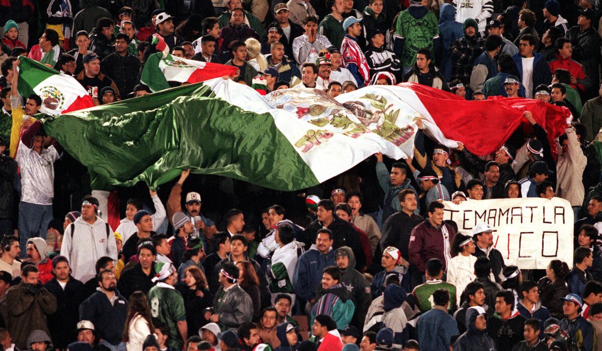 A huge flag of Mexico is unfurled by dozens of fans during a soccer match between Mexico and Argentina at the Los Angeles Coliseum on Feb. 10, 1999. Nearly 100,000 fans filled the coliseum.