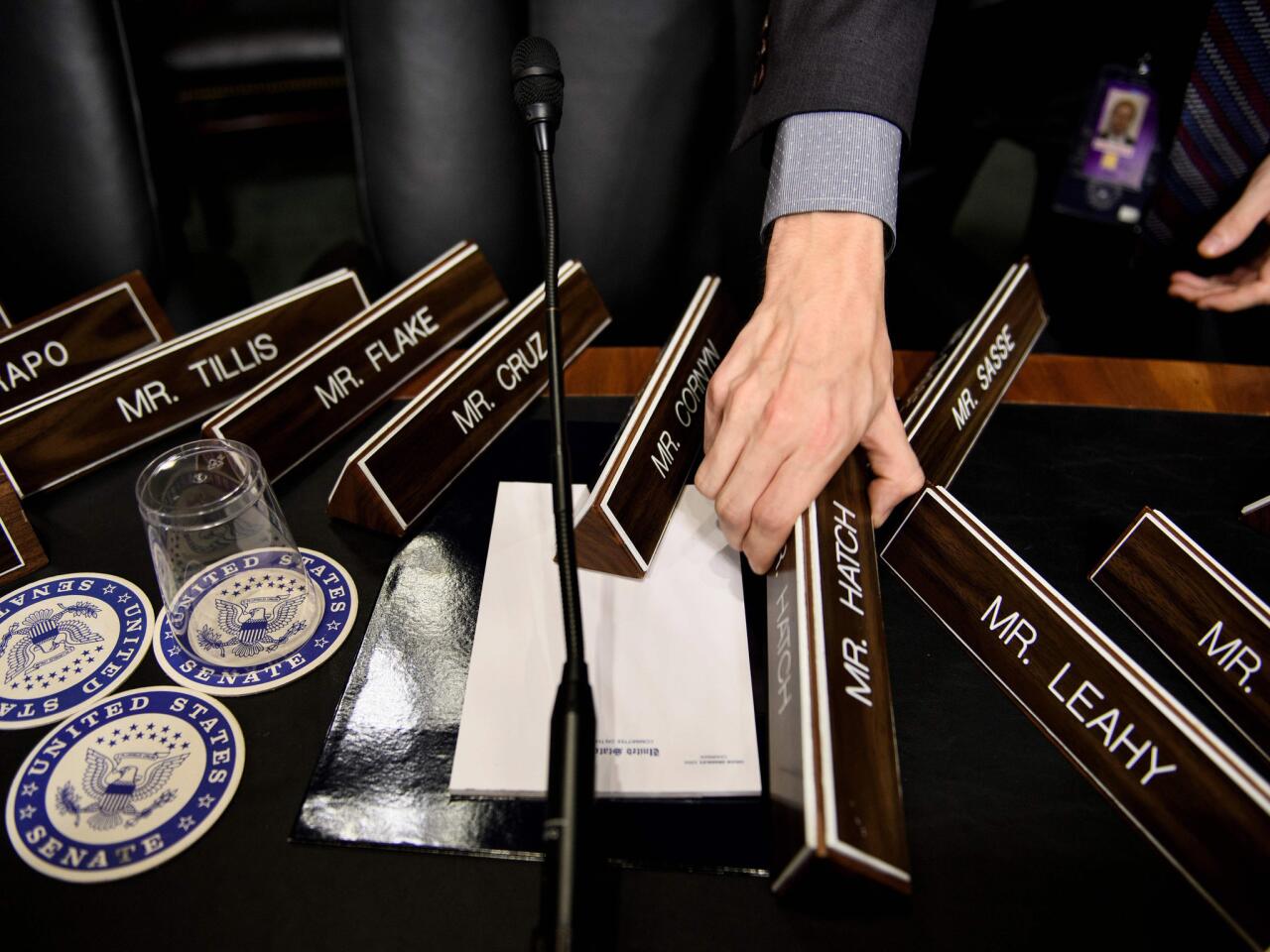 A staff member places name plates as the Senate Judiciary Committee's room on Capitol Hill in Washington, DC, during preparations one day before the hearing with Blasey Ford and Supreme Court nominee Judge Brett Kavanaugh.