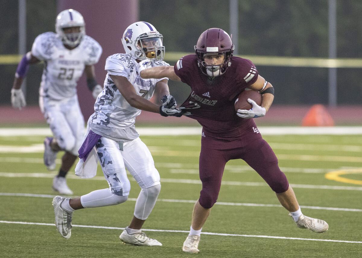 Laguna Beach's Jack Pigott, seen stiff-arming Hoover's Gabriel Harris on Aug. 24, 2018, caught a 38-yard touchdown pass in the Breakers' 10-7 loss at Dana Hills on Friday.