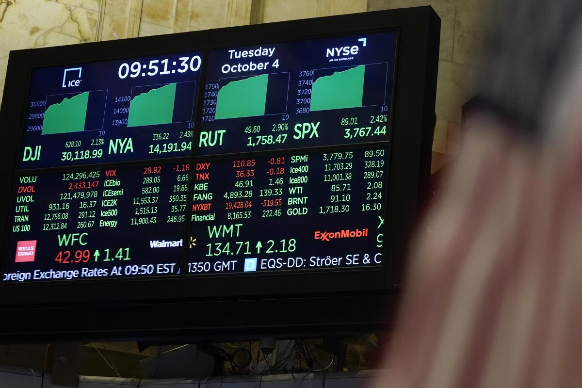 A digital display on a screen shows most indices up on the floor at the New York Stock Exchange.