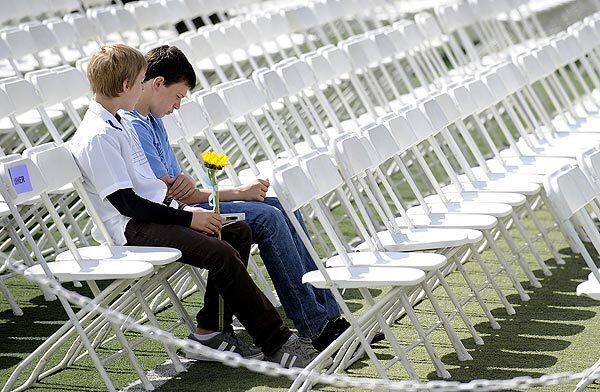 Two young boys with a ribbon-wrapped sunflower sit patiently for a memorial service to begin at Poway High School for senior Chelsea King, 17, who was attacked, killed and buried in a shallow grave at a park in the Lake Hodges area of San Diego County.