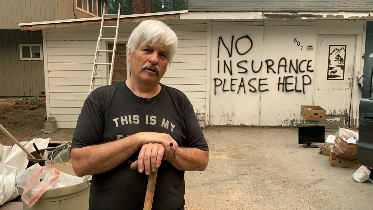 Tod Johnson stands in front of his house in South Lake Tahoe, Calif., on Tuesday, Aug. 31, 2021, a day after the city was ordered to evacuate because of the fast-growing Caldor Fire. He spray-painted his house, which is not insured, hoping that firefighters would help save it if the fire reaches his neighborhood. (AP Photo/Terry Chea)