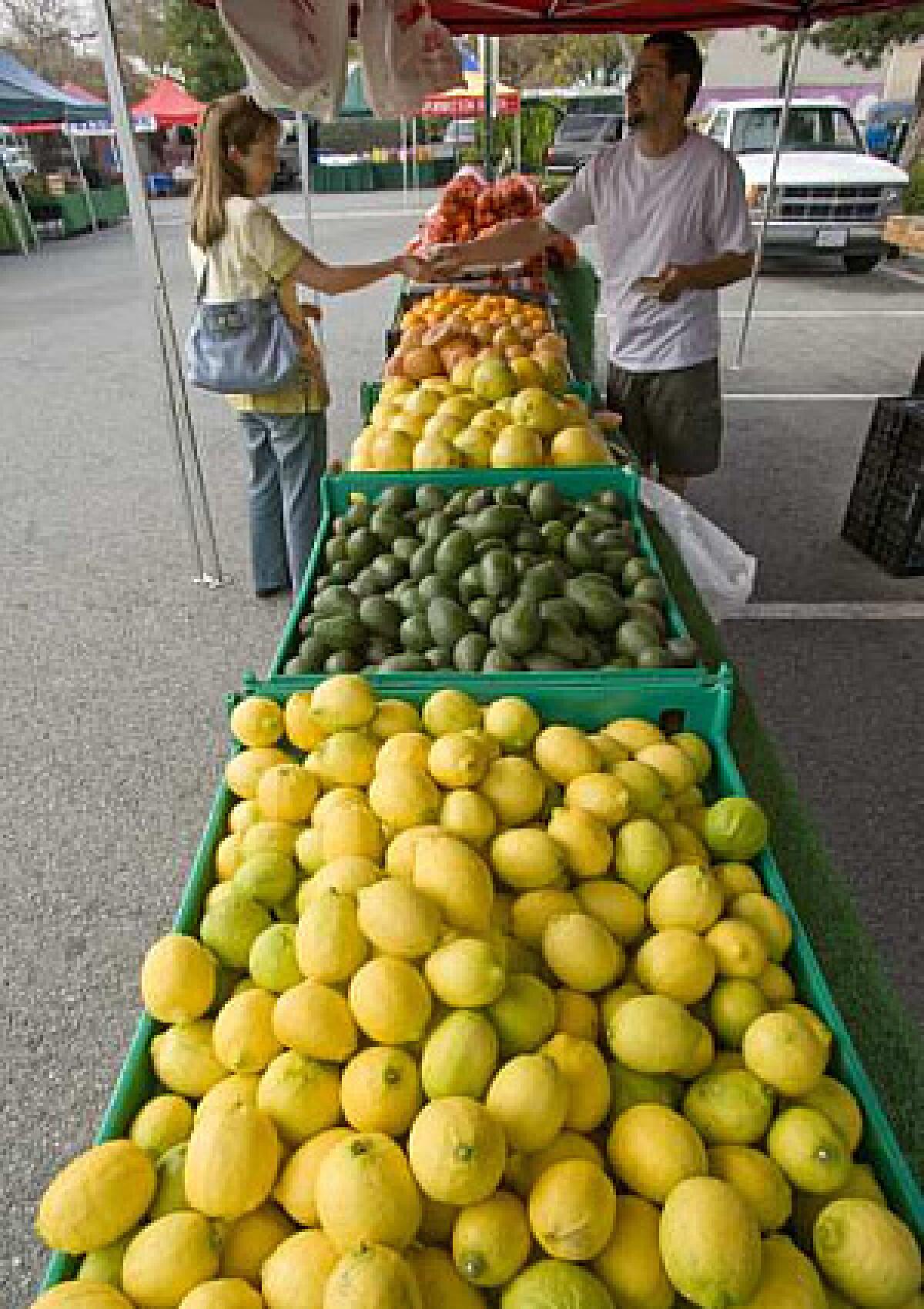 Jason Casper, a vendor for Tilden Farms, sells Valencia and navel oranges, Star Ruby grapefruit, Oroblanco pummelo hybrids, Hass avocados and Lisbon lemons, grown in Riverside and Pauma Valley, at the Whittier Uptown farmers market.