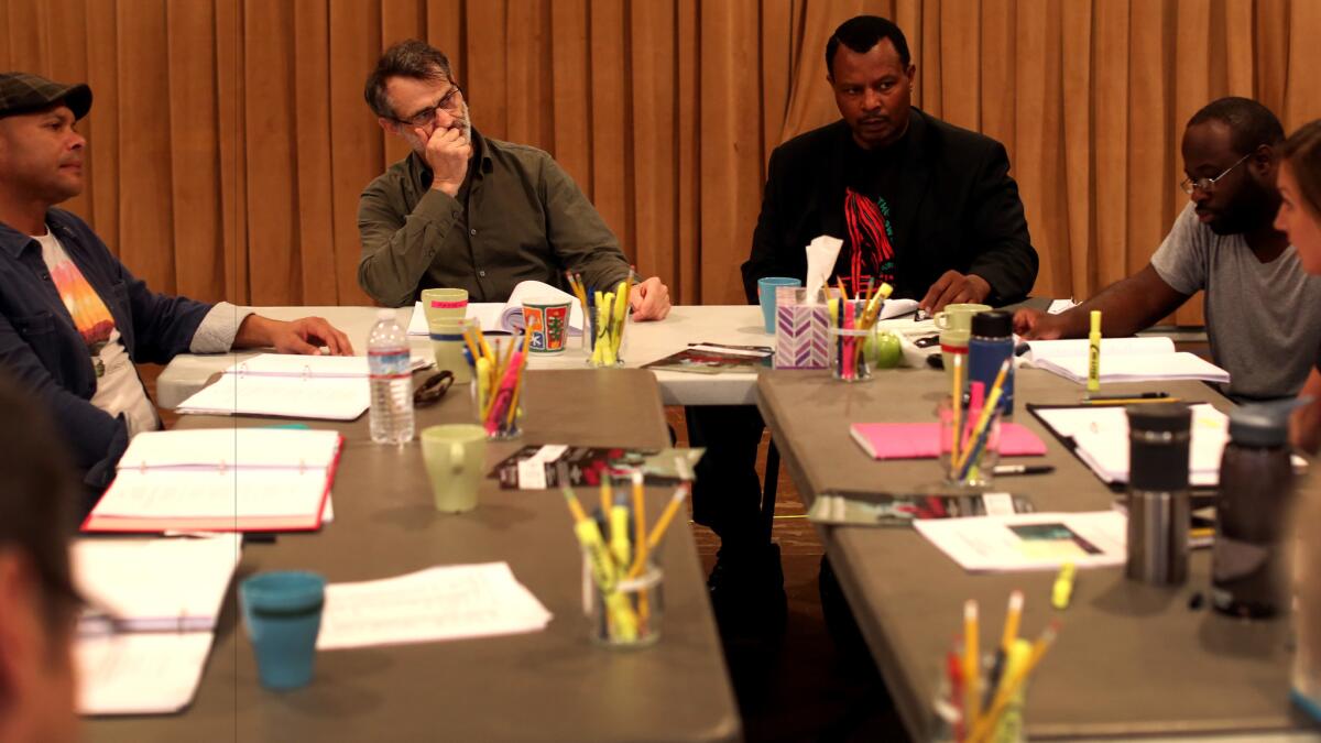 The "District Merchants" cast reads through the script early in rehearsals at South Coast Repertory. From left, Chris Butler (Bassanio), Matthew Boston (Shylock), Montae Russell (Antoine), Akeem Davis (Lancelot) and Helen Sage Howard Simpson (Portia). (Rick Loomis / Los Angeles Times)