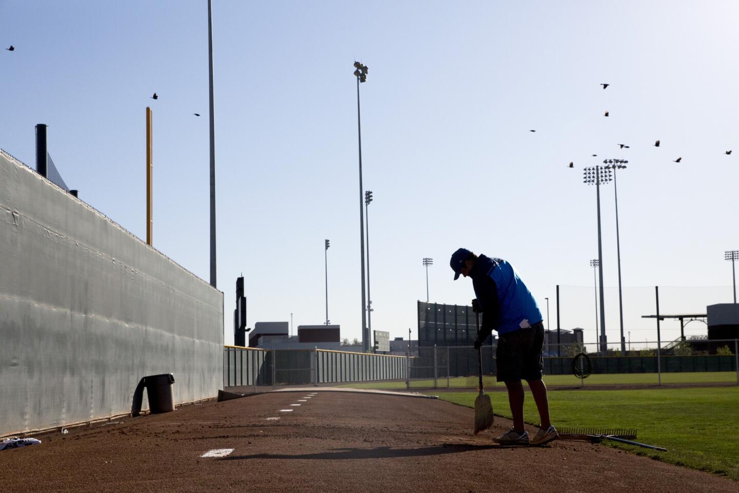 Matt Ramirez cleans the pitching mounds during spring training at Sloan Park Friday, Feb. 26, 2016, in Mesa, Ariz.