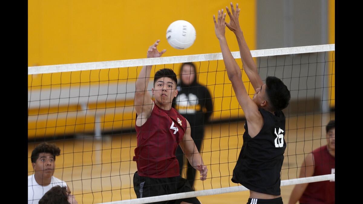 Ocean View High's Devon Vu, center, hits a shot at Godinez's Cesar Anaya in the first set of a Golden West League match at Godinez on Monday.