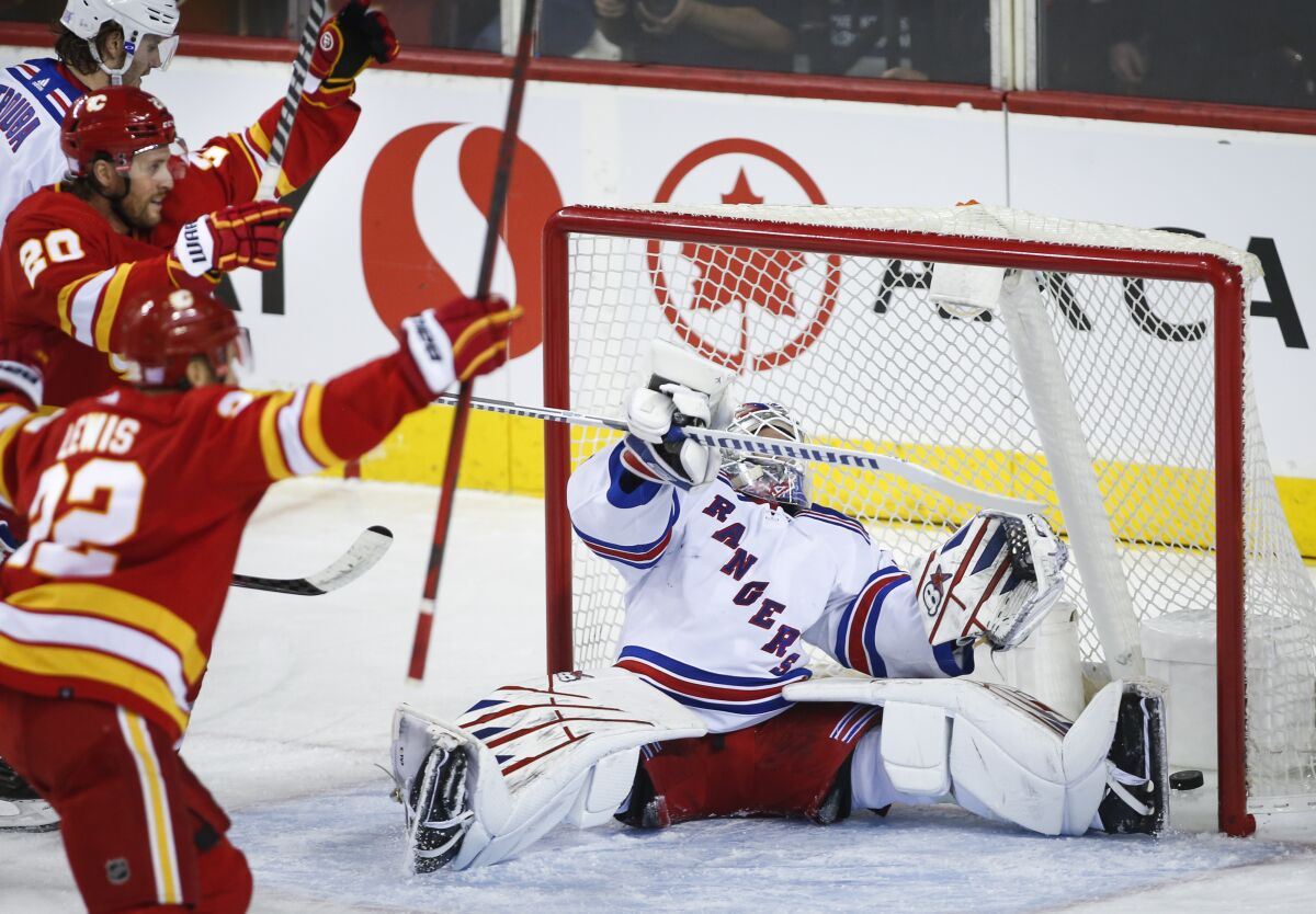 New York Rangers goalie Igor Shesterkin, right, reacts to letting in a goal as Calgary Flames' Blake Coleman, left rear, celebrates during the second period of an NHL hockey game Saturday, Nov. 6, 2021, in Calgary, Alberta. (Jeff McIntosh/The Canadian Press via AP)