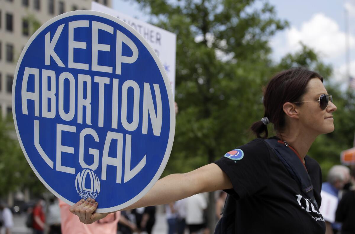 An abortion rights demonstrator holds a sign that reads "Keep abortion legal." 