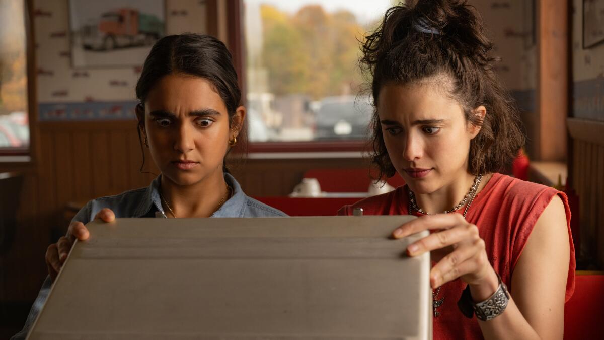 Two women look inside a briefcase.