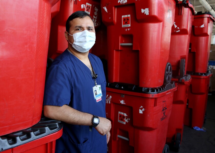 Alex Zavala, 37, of Cypress, next to clean biohazard bins at Kaiser Permanente Irvine.