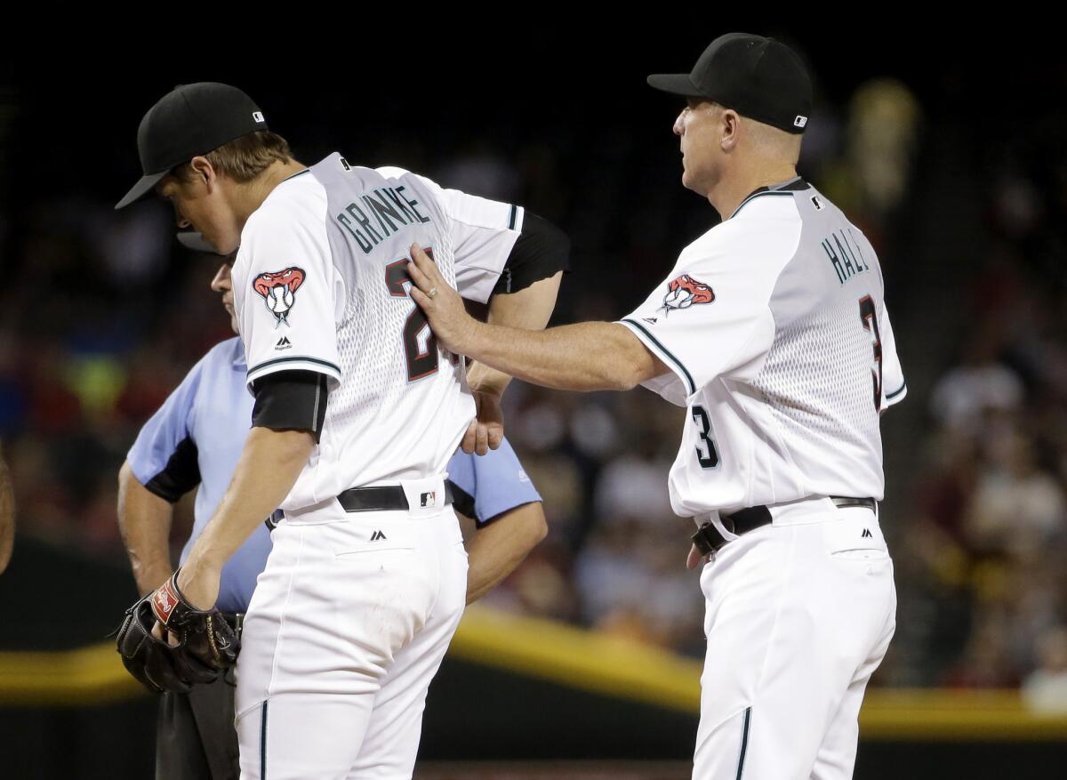 Diamondbacks Manager Chip Hale (3) removes starting pitcher Zack Greinke (21) from the game during the third inning due to injury on June 28.