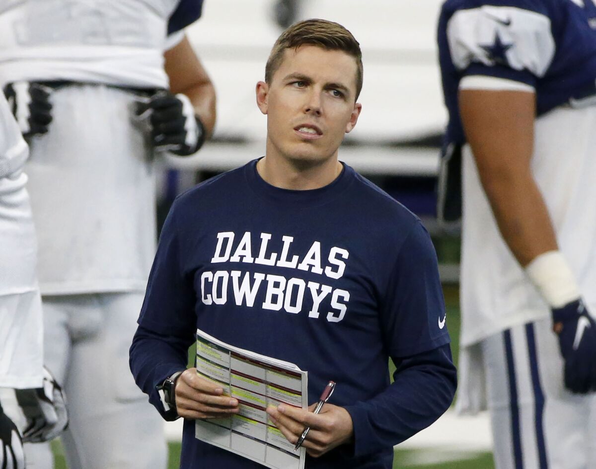 FILE - In this Aug. 30, 2020, file photo, Dallas Cowboys offensive coordinator Kellen Moore watches practice during an NFL football training camp in Arlington, Texas. Moore said Saturday, Jan. 2, 2021, he is no longer pursuing the Boise State job, and the Cowboys signed their play-caller to a multiyear contract extension. (AP Photo/Michael Ainsworth, File)